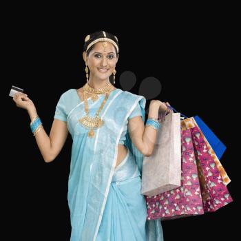 Portrait of a woman carrying shopping bags and a credit card
