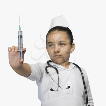 Girl dressed as a nurse and holding a syringe