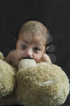Close-up of a baby boy playing with a teddy bear