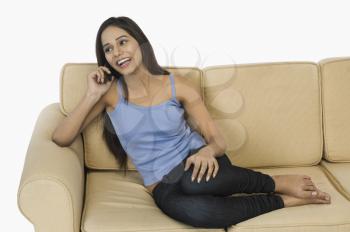 Woman sitting on a couch and talking on a mobile phone