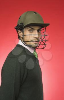 Businessman wearing a cricket helmet