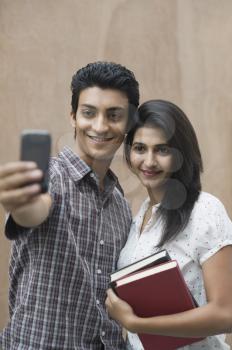 College students taking a picture of themselves with a camera mobile