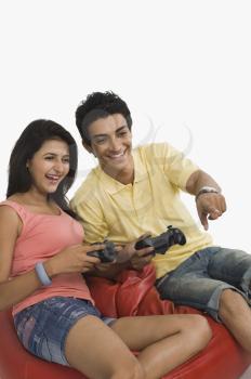 Couple playing a video game on a bean bag