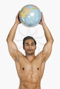 Portrait of a man holding globe over his head