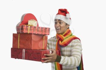 Man holding Christmas presents and smiling