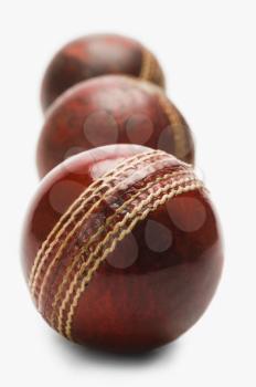 Close-up of old and new cricket balls in a row