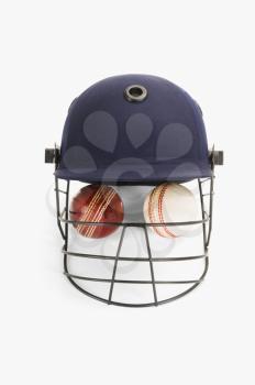 Close-up of cricket balls under a cricket helmet