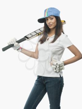 Portrait of a female cricket fan holding a bat and a ball