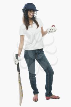 Portrait of a female cricket fan holding bat and a ball