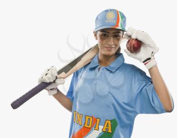 Portrait of a female cricketer holding a cricket bat and a ball