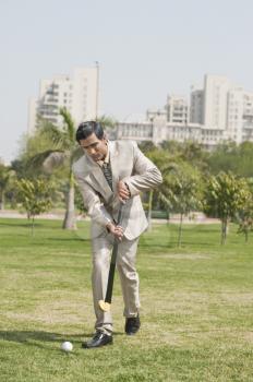 Businessman playing hockey in a park
