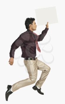 Businessman running with a blank placard