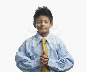 Boy dressed as a businessman and praying
