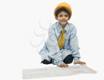 Boy dressed as an architect and working on a blueprint