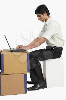 Store incharge using a laptop in a warehouse