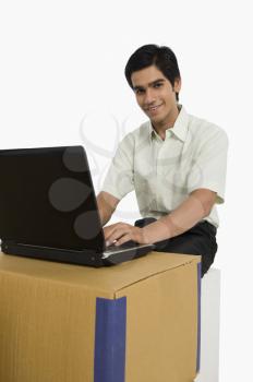 Store incharge using a laptop in a warehouse