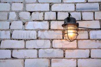 aging lamp on brick wall