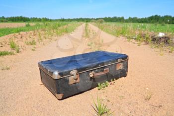 old valise on rural road
