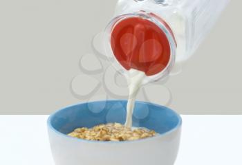 milk pouring into bowl wiht sweet balls isolated