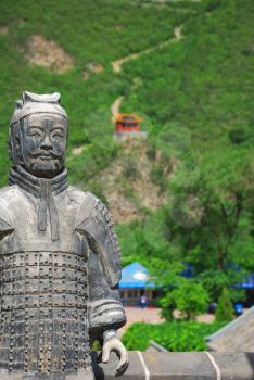 Old chinese stone warrior on the  Great Wall background