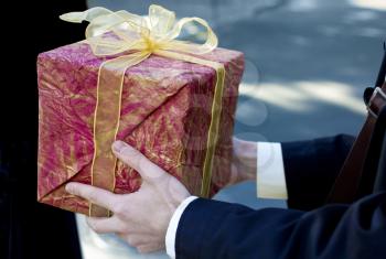 Man present red gift box with ribbon bow, side view