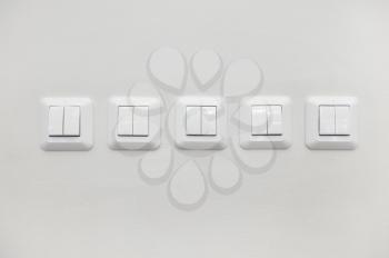 Many light white switches on the white wall