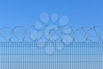 The barbed wire fence on blue sky background