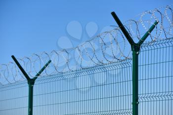 The barbed wire fence on blue sky background