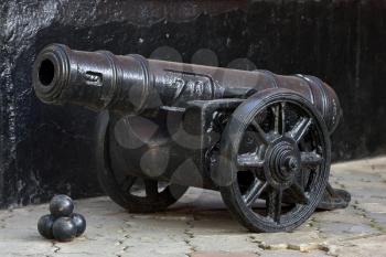 Old black cannon on a black background.