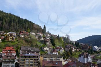Cute village in Germany on a hillside, apartment buildings on the background of the forest