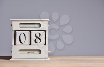 Retro calendar with the date March 8, International Women's Day and free text space on a gray wall background.