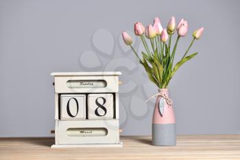 Retro calendar with the date of March 8 and tulips in a vase, International Women's Day and free text space on a gray wall background.