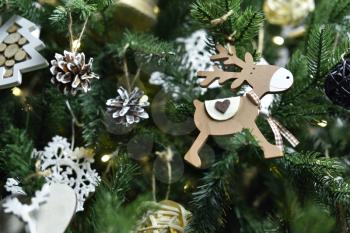 Small wooden toy deer decoration hanging on a Christmas tree