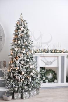 Beautiful New Year's interior with a white fireplace, Christmas tree