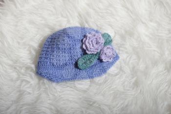 Cute children's knitted hat on a white carpet background