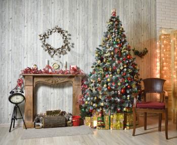 Brown Christmas interior with Christmas tree, wood fireplace and armchair