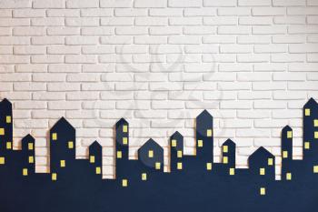 Decorations of the children's room for the New Year or Christmas, the silhouette of the city on a background of a white brick wall