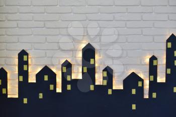 Decorations of the children's room for the New Year or Christmas, the silhouette of the city on a background of a white brick wall