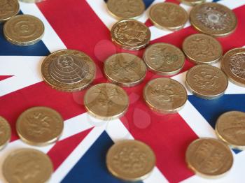 Pound coins money (GBP), currency of United Kingdom, over the Union Jack