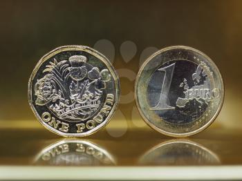 1 pound and 1 euro coin money over metallic background