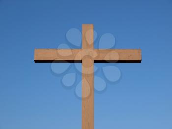 A wooden Christian cross over a blue sky