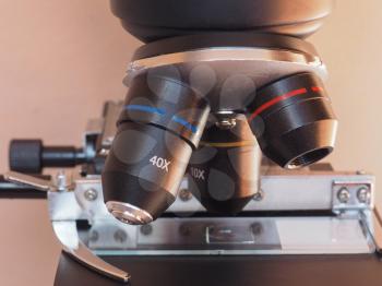 Detail of optical microscope lens and cross table with slide - selective focus