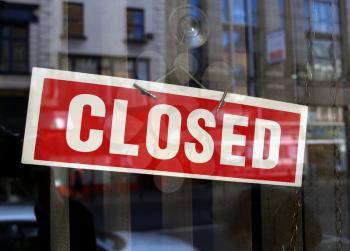 Closed sign a in shop window with blurred background reflections