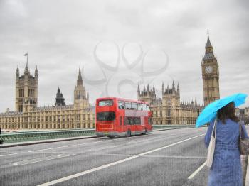 Rainy day at the Houses of Parliament with red bus and blue girl, London, UK