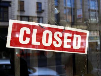 Closed sign in a shop showroom with reflections