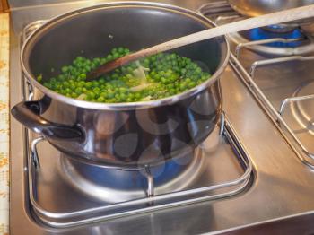 Green peas in a saucepot on gascooker