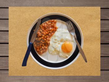 Vegetarian English breakfast with baked beans and fried egg on pub table, top view