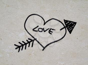 Love heart and Cupid arrow graffiti on a wall