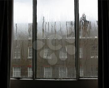 Urban scene seen through a window in a rainy day