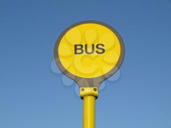 Yellow bus stop sign over blue sky background